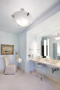 ein Badezimmer mit einem Waschbecken, einem Spiegel und einem Stuhl in der Unterkunft The Ivy Hotel in Baltimore