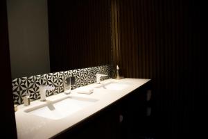 a white sink sitting under a mirror in a bathroom at IT Boutique Hotel & Restaurant in Playa del Carmen