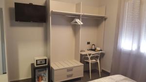 een slaapkamer met een bed en een bureau in een kamer bij Alma Hotel in Palermo