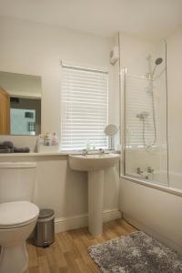 een badkamer met een toilet, een wastafel en een douche bij The Lodge House Callander in Callander