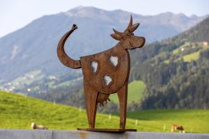 uma estátua de uma vaca no topo de uma colina em Hochfeldhof em Zell am Ziller