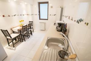 a kitchen with a sink and a table with chairs at 6 Apartments in Predeal