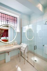 een badkamer met een wastafel en een spiegel bij The Ivy Hotel in Baltimore