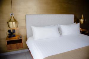 a bed with white sheets and pillows in a room at IT Boutique Hotel & Restaurant in Playa del Carmen