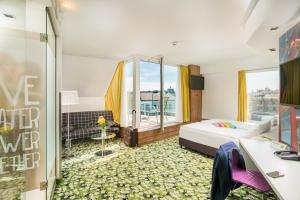 ein Schlafzimmer mit einem Bett und einem großen Fenster in der Unterkunft Ibis Styles Wien City in Wien