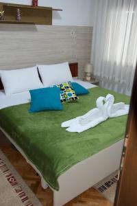 łóżko z dwoma białymi ręcznikami na górze w obiekcie Apartment Elmari w mieście Prilep