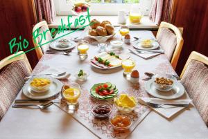 una mesa de comedor con comida, bebidas y naranjas. en The Conscious Farmer Bed and Breakfast Sauerland, en Willingen