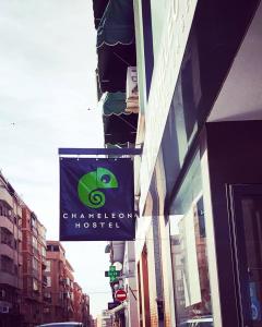 a building with a green sign on the side of it at Chameleon Youth Hostel Alicante in Alicante
