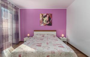 a bedroom with purple walls and a bed with two lamps at Apartment Marino in Poreč