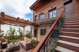 a home with a staircase and a patio with chairs at Polys Guest House in Katachás