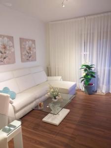 a living room with a white couch and a table at Sesto Calende Centro in Sesto Calende