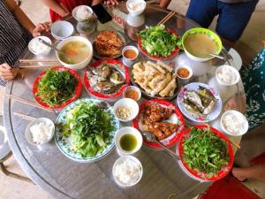 a table with a bunch of food on it at HOMESTAY LOAN ANH in Ly Son