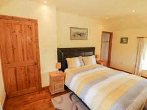 a bedroom with a bed and a wooden door at Penllyn in Llanfairpwllgwyngyll