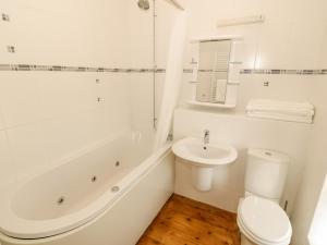 a white bathroom with a toilet and a sink at Penllyn in Llanfairpwllgwyngyll +16 photos