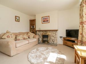 a living room with a couch and a fireplace at Crooked Well in Bath