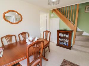 een eetkamer met een houten tafel en een spiegel bij Crooked Well in Bath