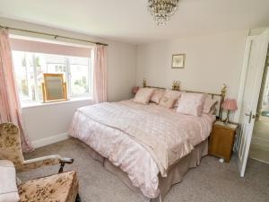 a bedroom with a bed and a chair and a window at Crooked Well in Bath