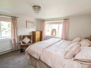 a bedroom with a bed and a chair and windows at Crooked Well in Bath