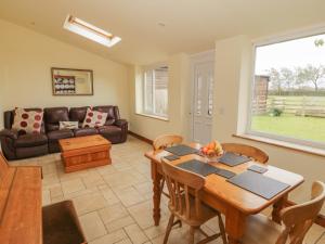 a living room with a table and a couch at Bron Gadair in Llanfairpwllgwyngyll