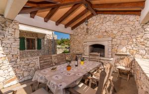 een stenen patio met een tafel en een open haard bij Villa Albina Skitaca in Koromačno