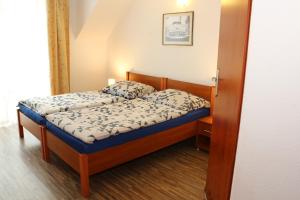 a small bedroom with a bed with a wooden frame at Aqua Villa Grzybowo Pension in Grzybowo