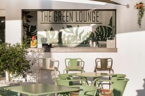 a restaurant with tables and chairs and a sign that reads the green lounge at Belmar Spa & Beach Resort in Lagos