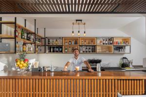 a man standing behind a counter in a bar at Belmar Spa & Beach Resort in Lagos