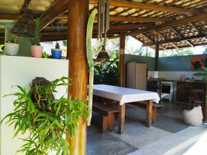 uma mesa e um banco debaixo de uma pérgola numa cozinha em Estalagem Itamambuca em Ubatuba