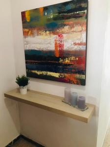 a painting hanging on a wall with candles on a shelf at Apartamentos Europa, Playa del Inglés in Playa del Ingles