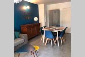 マルセイユにあるLe 13OR - Appartement plein centre parking et terrasseのダイニングルーム(テーブル、青い椅子付)