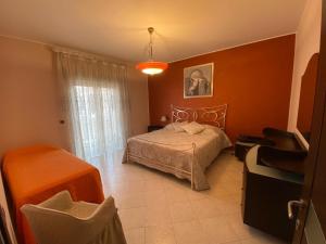 1 dormitorio con 1 cama con pared de color naranja en Casa Vacanze Sciascia, en Monforte San Giorgio Marina