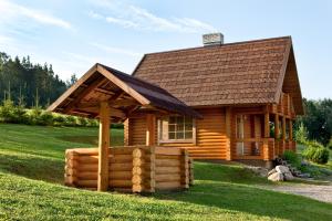 a log cabin with a gazebo in the grass at Partsilombi Holiday Home in Otepää