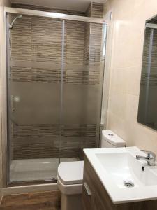 uma casa de banho com um chuveiro, um WC e um lavatório. em Valencia Gold Beach em Valência