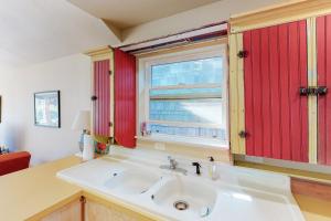 a kitchen with a white sink and a window at Beach Cabin Getaway in Rockaway Beach
