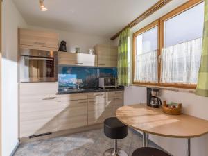 a kitchen with wooden cabinets and a wooden table at Haus Laimbauer in Kirchdorf in Tirol