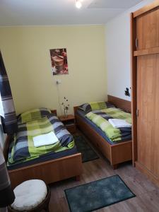 Habitación con 2 camas y puerta a un dormitorio en Tündér Szálló en Eplény