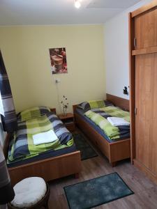 a room with two beds and a door to a bedroom at Tündér Szálló in Eplény