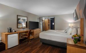 a hotel room with a large bed and a desk at The Beeman Hotel in Dallas