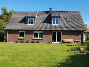 a brick house with a lawn in front of it at Ferienwohnungen am Aussendeich in Nordstrand