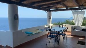 a patio with a table and chairs and the ocean at La Casuzza Dei Re in Malfa