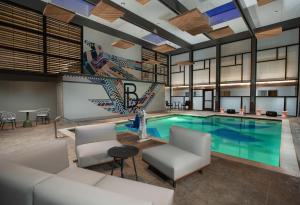 Una gran piscina con sillas y una mesa. en The Beeman Hotel en Dallas