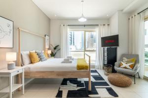 a bedroom with a bed and a chair at GuestReady - Brown Sugar in Dubai