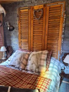 a bedroom with a bed with a wooden headboard at Chez steph et frank in Morez