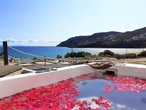 a bath tub filled with red flower petals at Sea Side Studios & Houses in Kalo Livadi