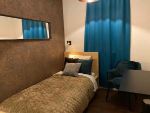 a bedroom with a bed and a mirror and a chair at B&B by the C in Vlissingen