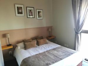 - une chambre avec un lit doté de draps et d'oreillers blancs dans l'établissement Logis Hotel Restaurant l'Orée Des Bois, à La Breille-les-Pins