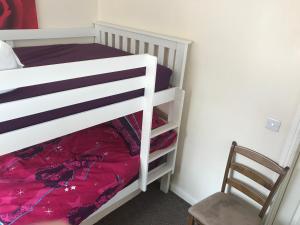 Un dormitorio con una litera y una silla. en HOUSE shared, New Build 36 Nottingham 3bedrooms, en Nottingham