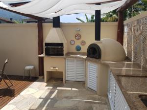 a outdoor kitchen with a pizza oven in a patio at Linda Casa em Juquehy in Juquei