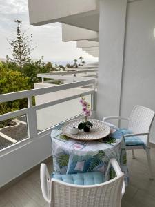 un tavolo e sedie su un balcone con vista sull'oceano di BEACH LAS AMERICAS SUITE a Playa Fañabe