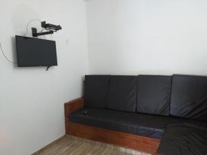 a black couch in a room with a camera on the wall at Recanto das Termas, Chalés in Termas do Ibirá